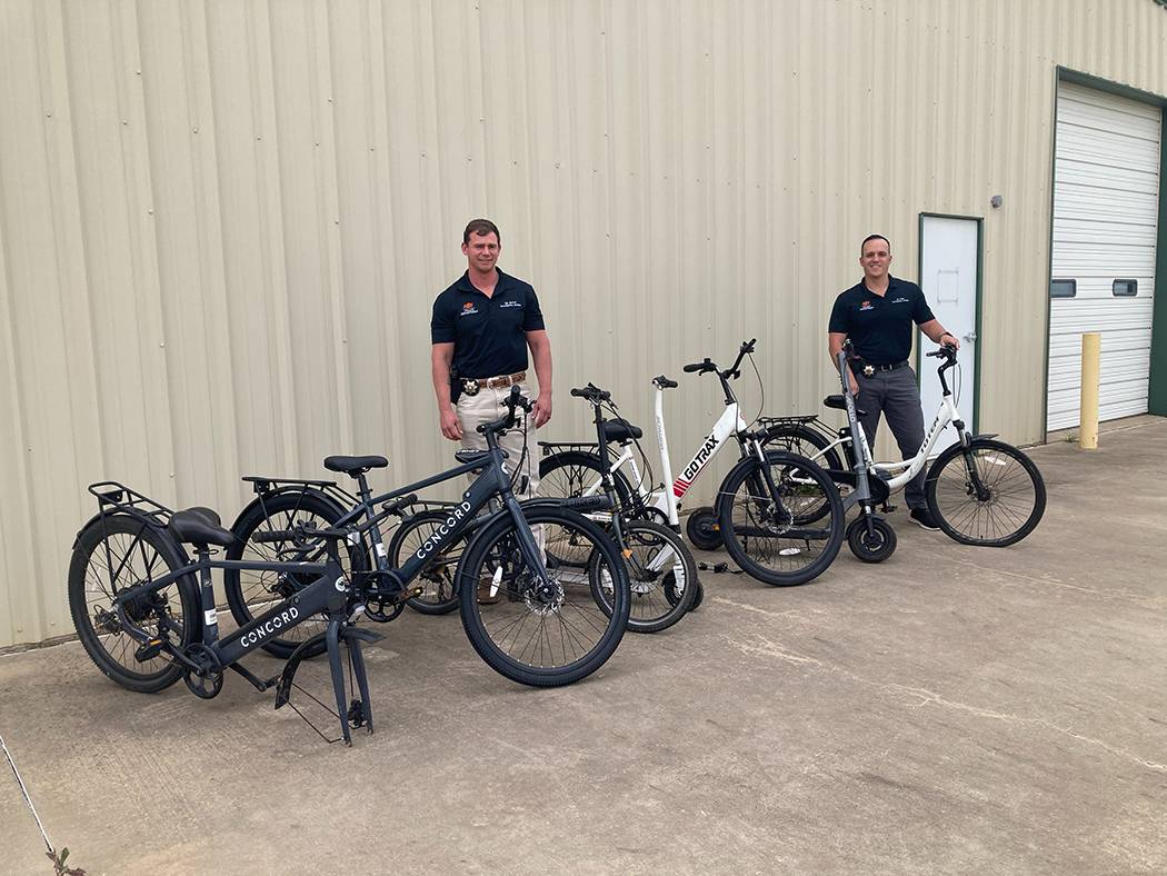 Sgt. Kyle McCool and Investigator Jacob Abad with recovered stolen bikes and scooters.